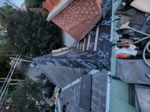 Progress photo taken from flat roof showing Grace Select underlayment fully installed on main slope with wood plank work platforms on metal jacks during slate roof replacement in Harbord Village Toronto by Right Choice Roofing and Repair