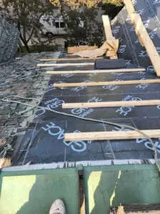 Progress photo looking up main slope from flat roof showing Grace Select underlayment fully installed with 2x4 step ups and wood plank work platform on metal jacks during slate roof replacement in Harbord Village Toronto by Right Choice Roofing and Repair