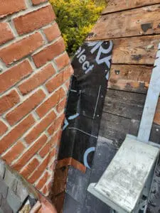 Different angle of Grace Ice and Water Shield underlayment Flashing turned up the side of a brick Chimney on a Rosedale Toronto heritage Slate Roof by Right Choice Roofing and Repair