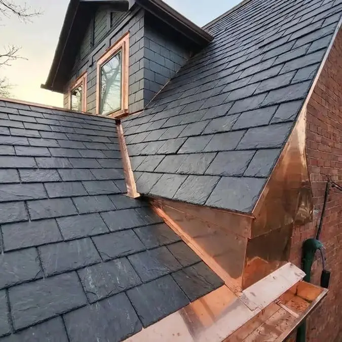 Completed slate roof replacement in Toronto showing natural slate tiles, custom copper valley, eavestrough, soffit bulkhead enclosure and copper window frame, sill and lintel coverings by Right Choice Roofing and Repair.