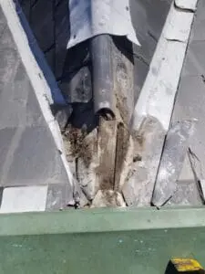 Progress photo showing wildlife damaged lead ridge cap being removed from slate roof in Harbord Village Toronto during replacement project by Right Choice Roofing and Repair