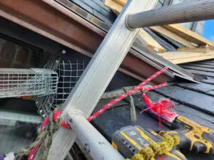 Right Choice Roofing and Repair inspecting a compromised soffit bulkhead with wildlife infestation on a Toronto slate roof.