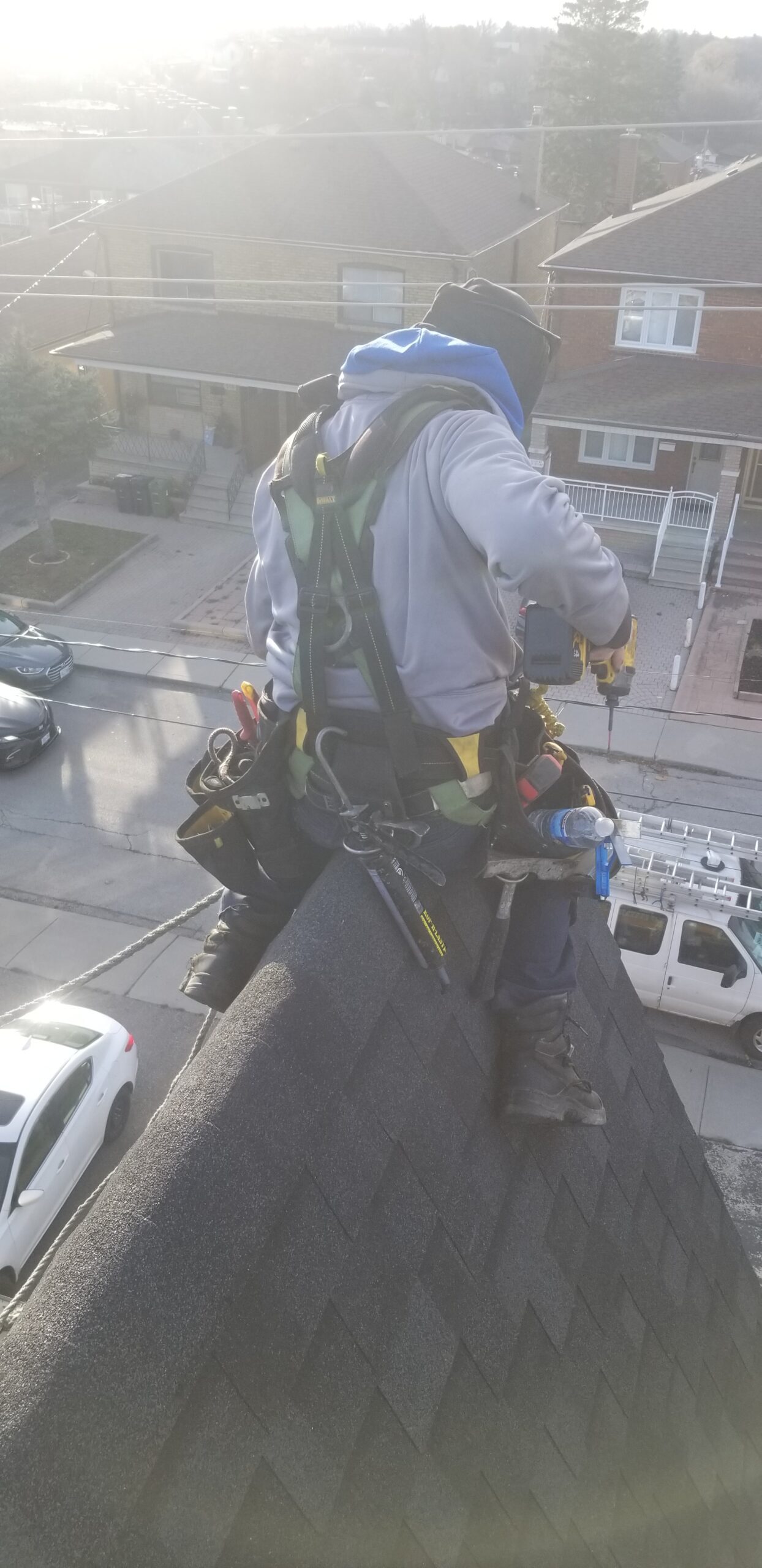 Local Toronto Roofer on a steep Roof in the GTA providing Roof maintenance repair in the winter to repair a Roof leak on a Roof that needs Roof Shingles repair by Toronto's number one Roofing Company in the GTA